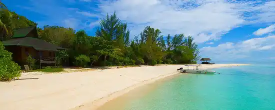 Panoramic view of the pristine white sand beach and turquoise waters of Lankayan, a luxury private island resort perfect for a honeymoon in Sabah.