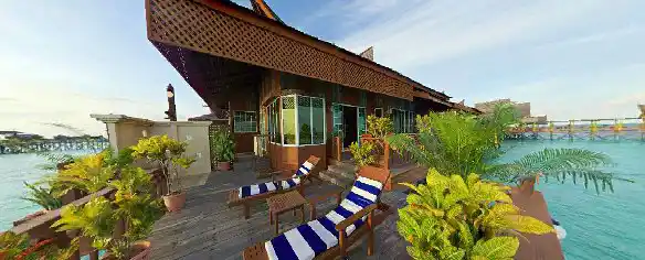 Expansive private sun deck of the Bougainvilla chalet at Mabul Water Bungalows, complete with lounge chairs for relaxing over the water.