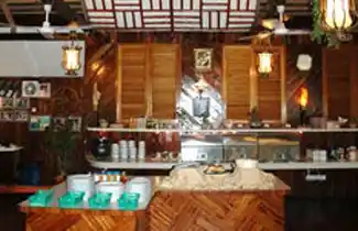 Buffet serving station at the Sipadan-Mabul Resort (SMART) restaurant, offering a variety of dishes in a rustic, tropical setting.