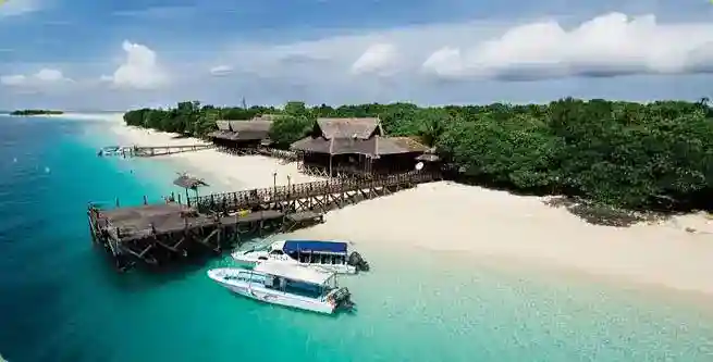 Breathtaking aerial view of the private Mataking Island Dive Resort, showcasing its extensive coral reefs, white sand beaches, and luxury 5-star amenities.