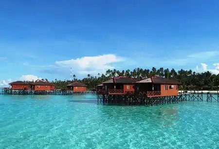 Luxury overwater bungalows of Maratua Paradise Resort, standing in the brilliantly clear turquoise sea of a private island in East Kalimantan.