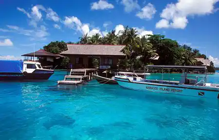 Dive boats moored at the jetty of Nabucco Island Resort, a PADI dive resort surrounded by brilliant blue water in East Kalimantan.