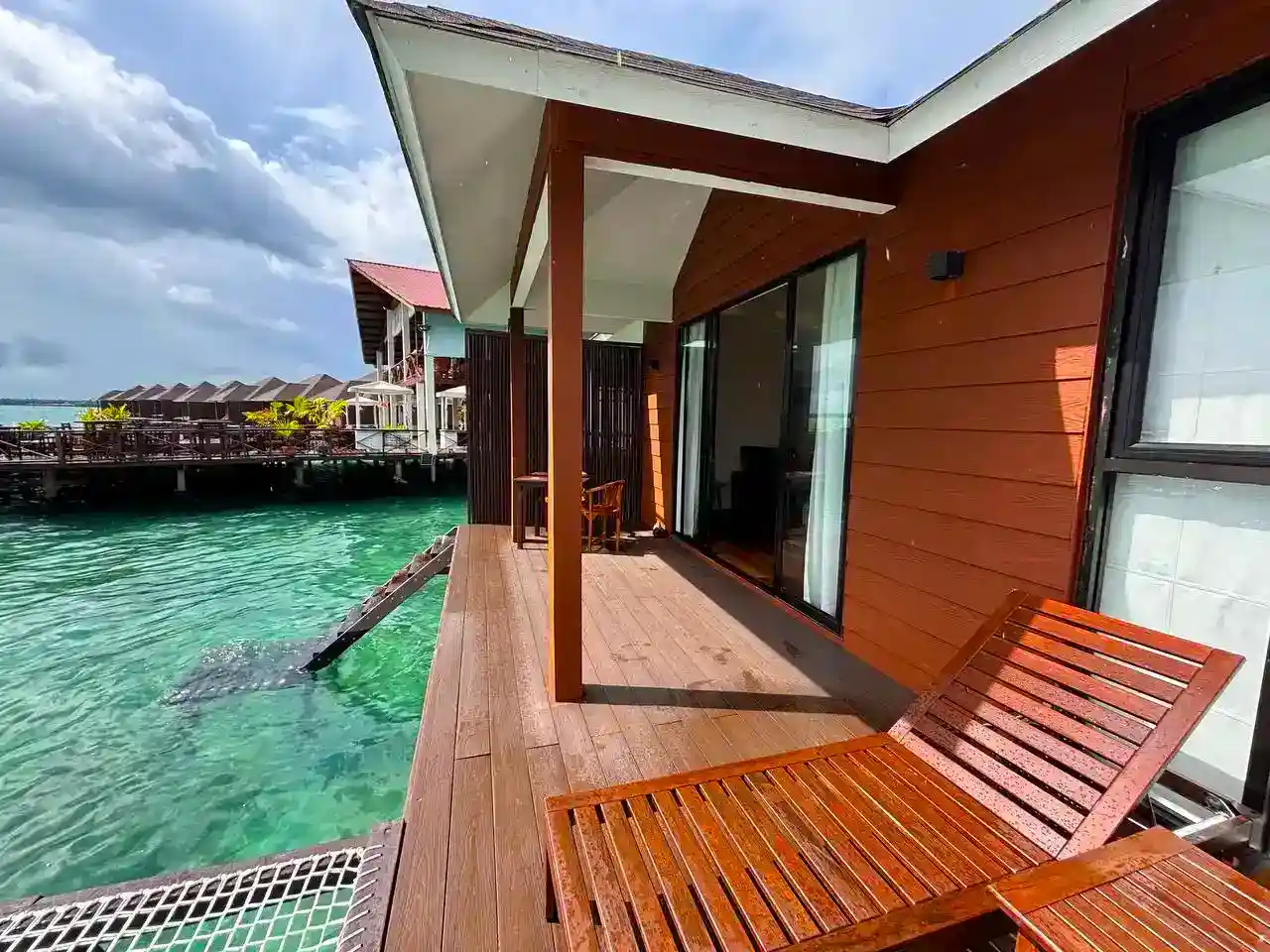 Private balcony at Sea Star Resort with direct stair access into the clear sea, perfect for snorkeling right from your overwater chalet.