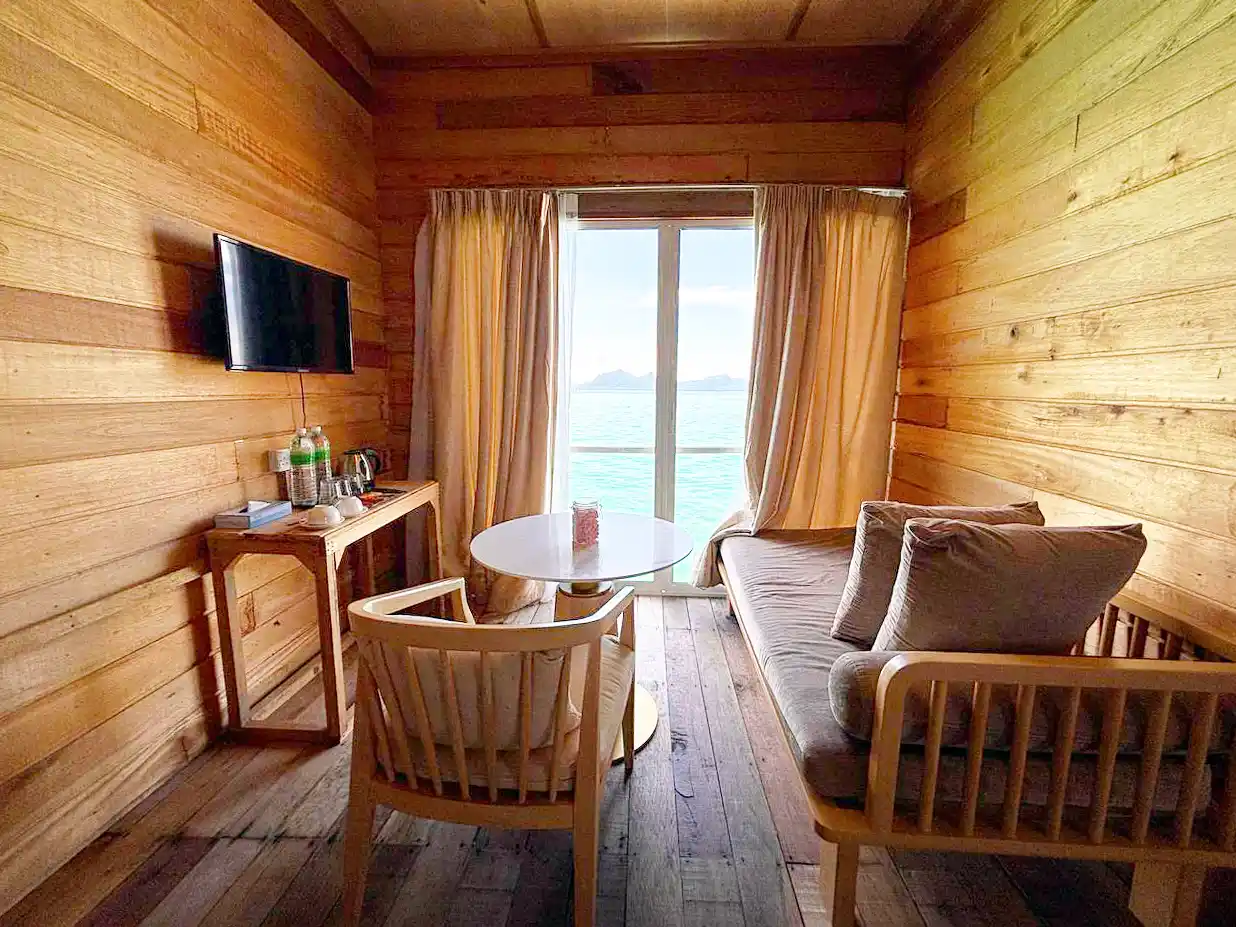 Cozy living room area in a chalet at Sisipan Island Resort, with comfortable seating perfectly positioned to enjoy the stunning sea view.