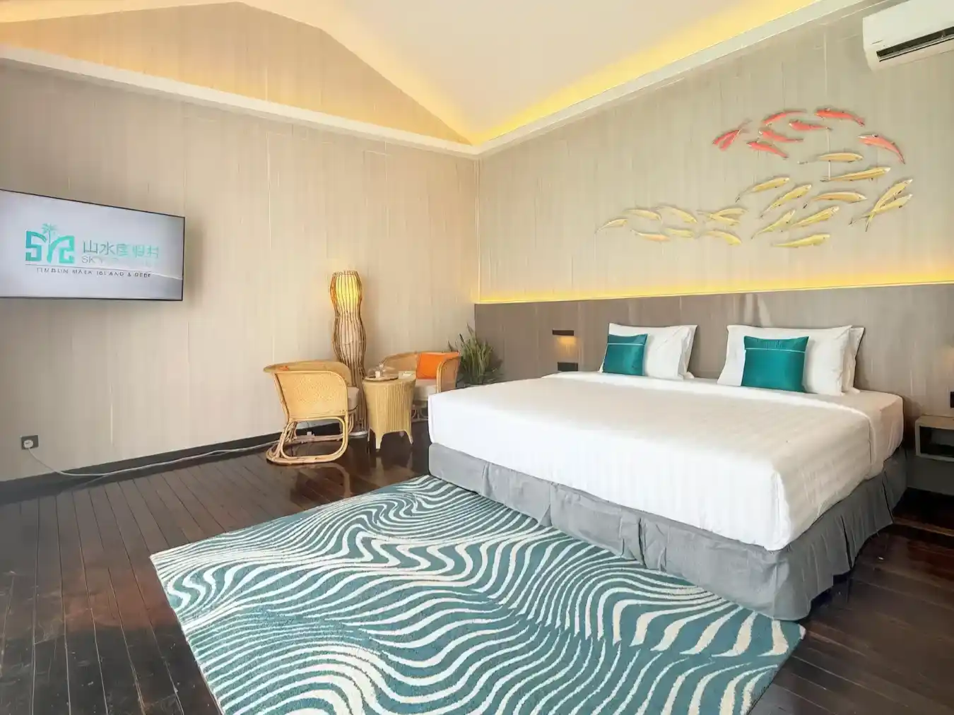 Stylish king-size bedroom at Sky Resort Timbun Mata, featuring modern, ocean-themed decor including a fish sculpture and a wave-patterned rug.