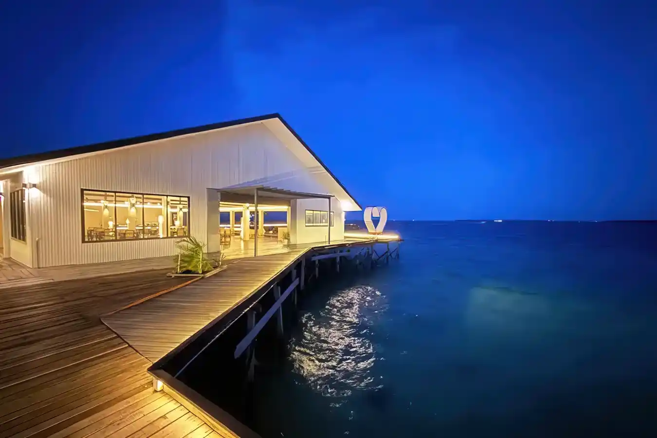 Stunning view of the Sky Resort restaurant during the blue hour, with the modern building beautifully illuminated against the deep blue twilight sky.